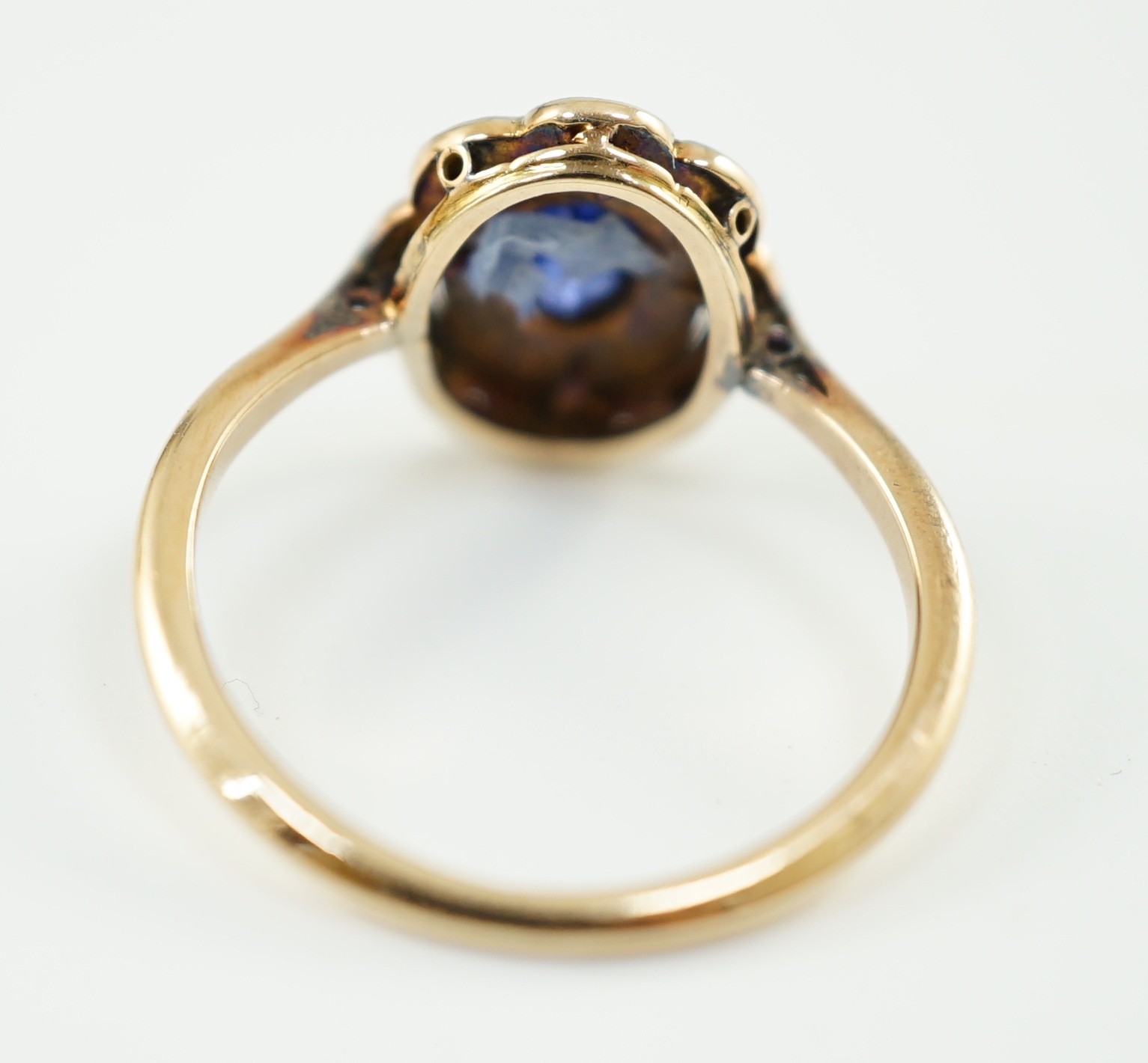 An early 20th century gold, sapphire and millegrain set rose cut diamond set oval cluster ring